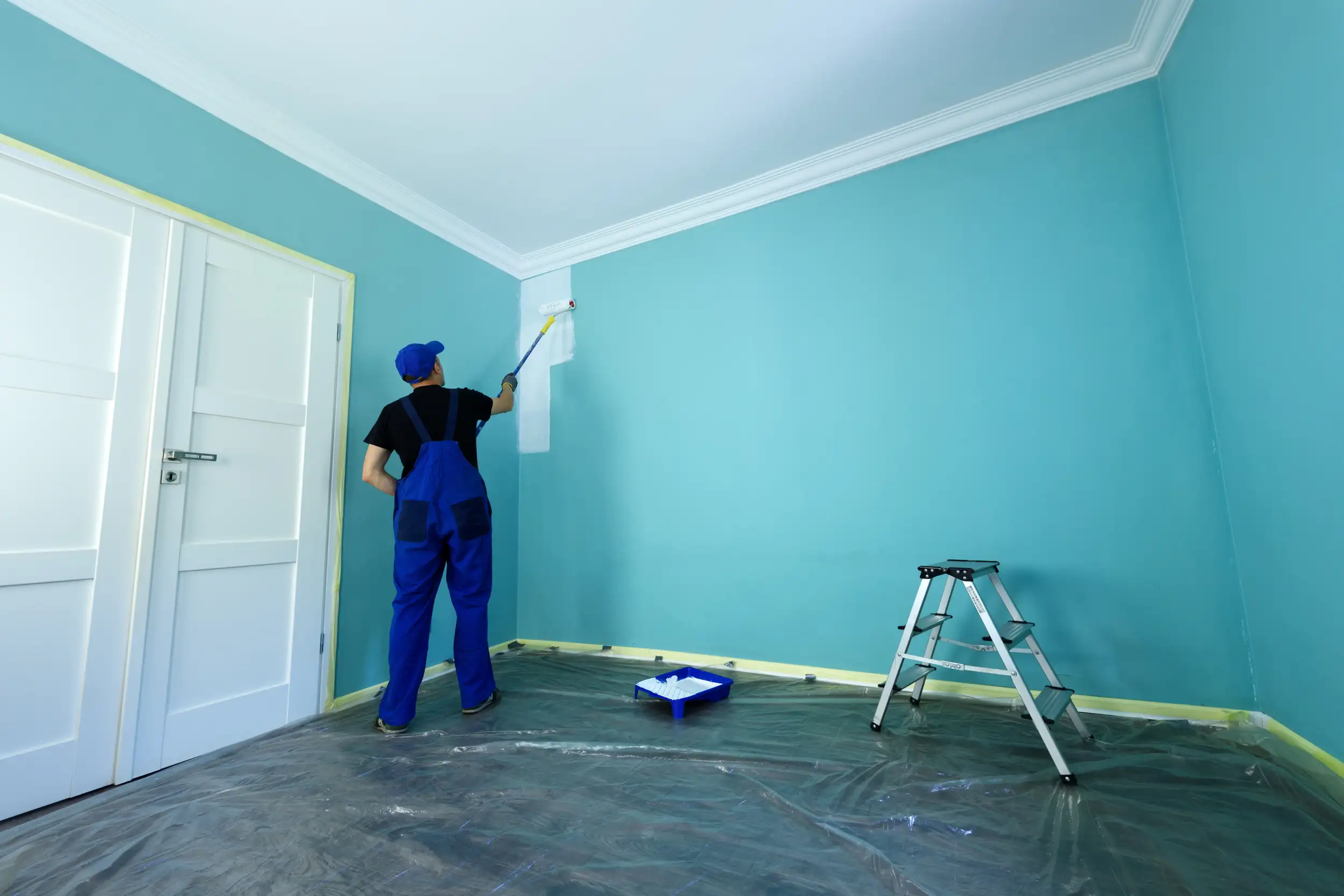 A man painting the interior walls of the house with bright colors.